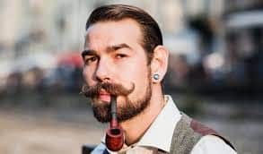 Man smoking a pipe with a Verd style beard credit: The rugged bros
