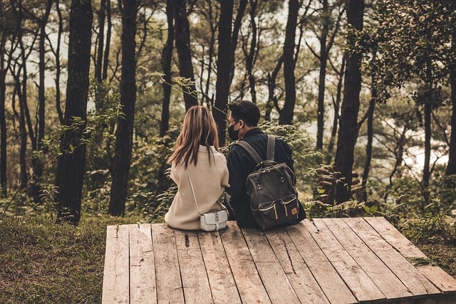 couple sitting together showing a romantic moment in the woods